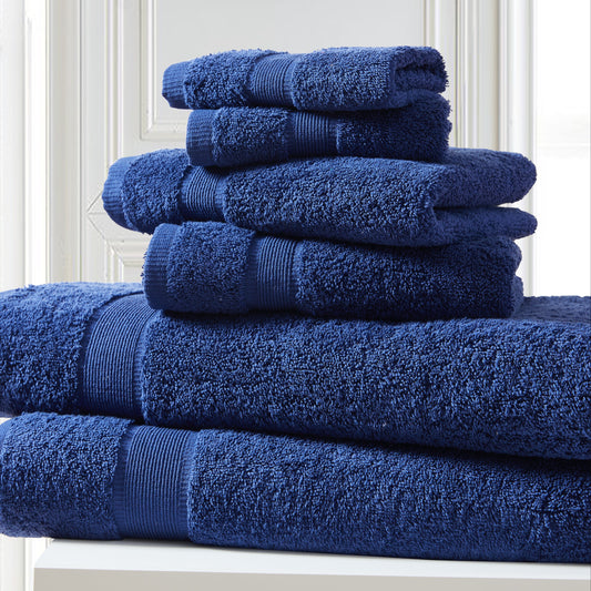 Stack of blue towels on a white surface with a white wall background