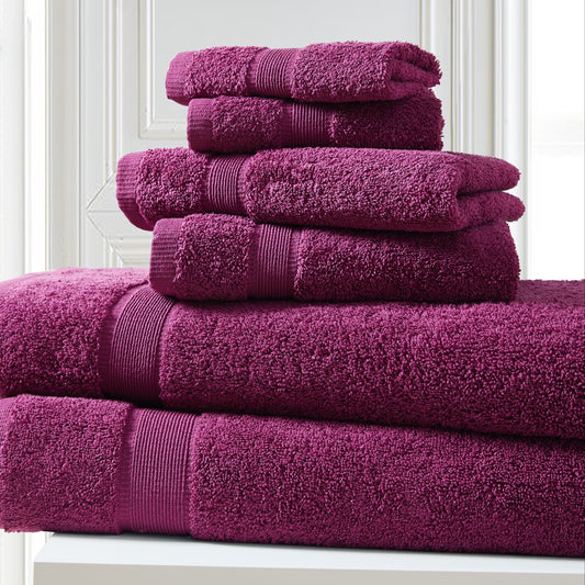 Stack of purple towels on a white surface with a light gray wall background