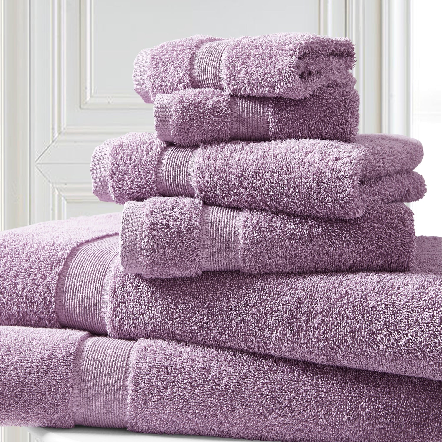Stack of purple towels on a white surface with a light background