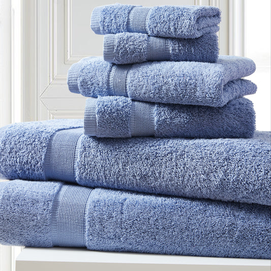 Stack of blue towels on a white surface with a light gray wall background