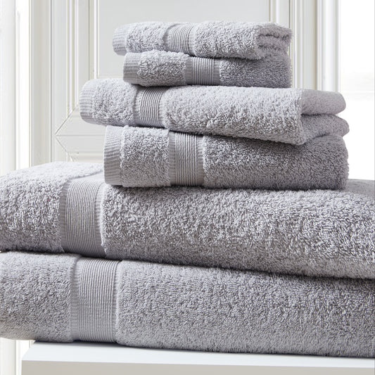 Stack of gray towels on a white surface with a light background