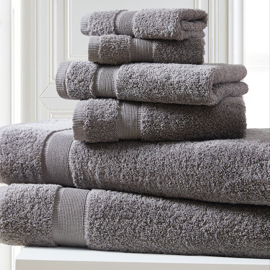 Stack of gray towels on a white surface with a light background