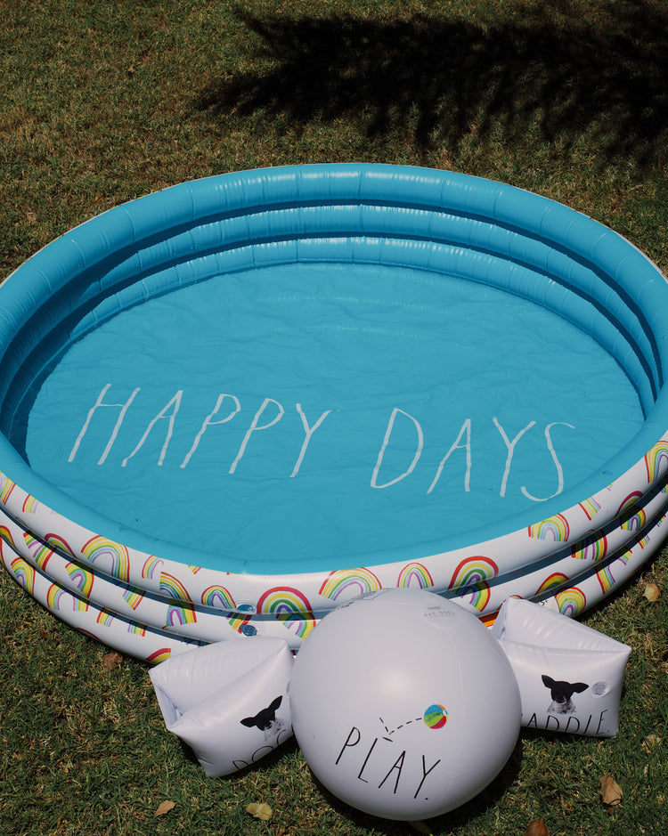 Inflatable pool with 'Happy Days' text on grass