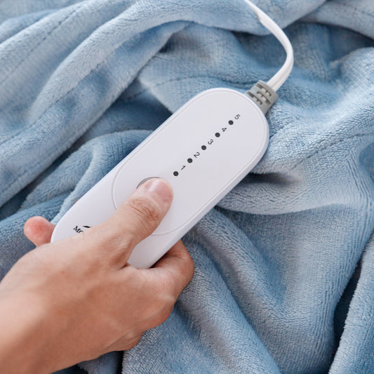 Blue blanket on a bed with white pillows in a bedroom setting