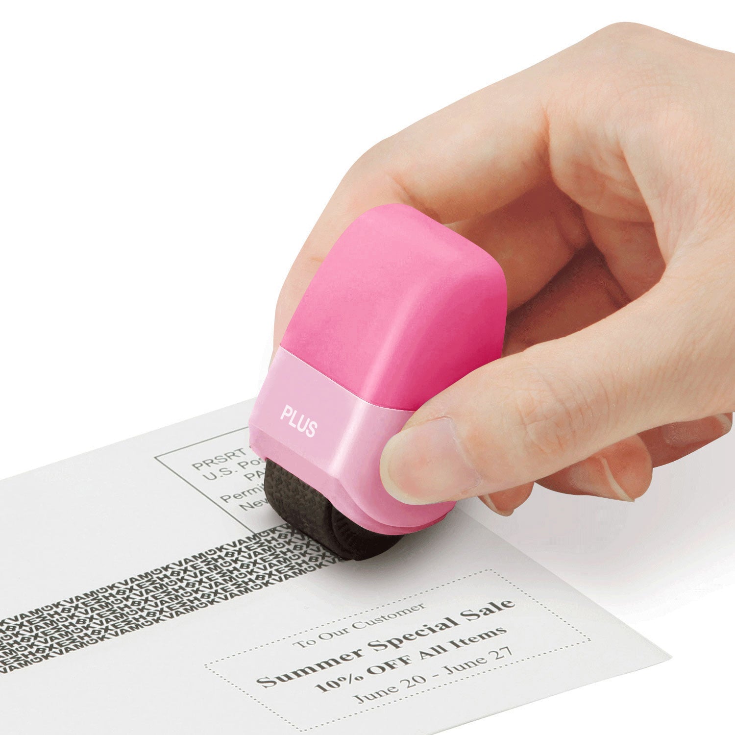 Hand using a pink PLUS brand stamp on a document with text and a barcode.
