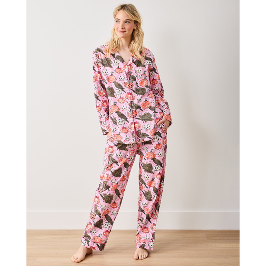 Woman wearing a pink floral onesie against a plain background