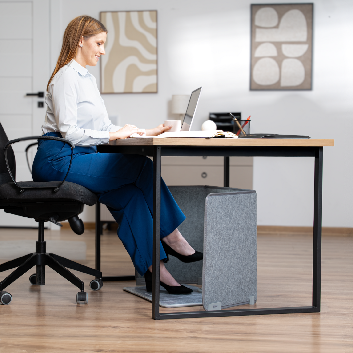 Woman sitting at a desk with a laptop in an office setting