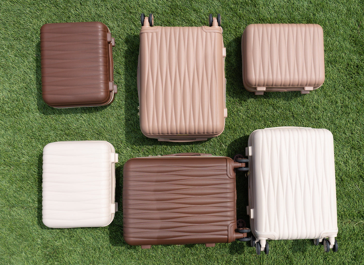 Set of suitcases in various colors on a grassy background