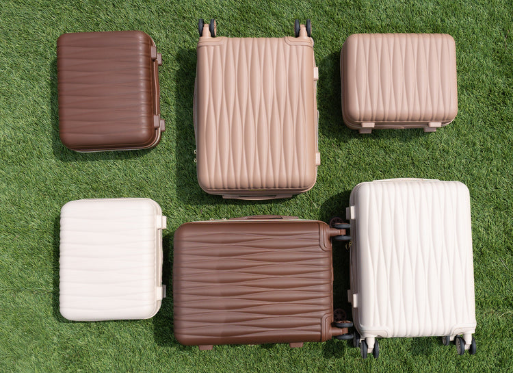 Set of suitcases in various colors on a grassy background