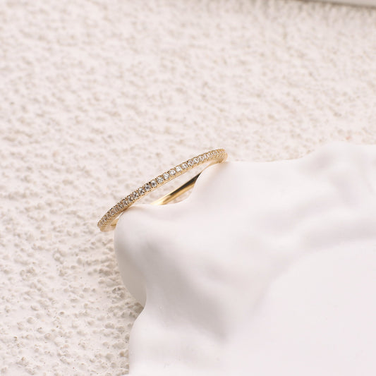 Gold ring with small diamonds on a white background