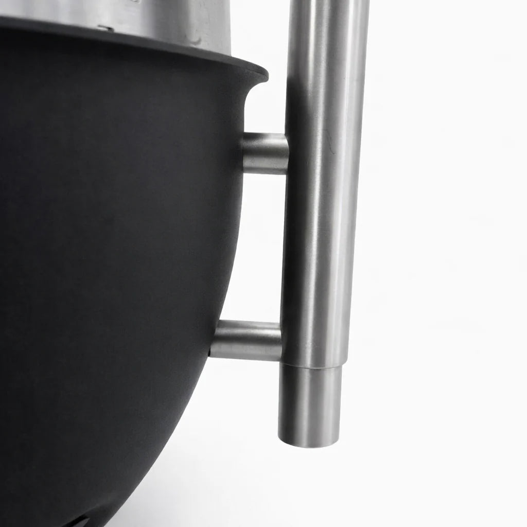 Close-up of a black pot with a stainless steel handle on a white background
