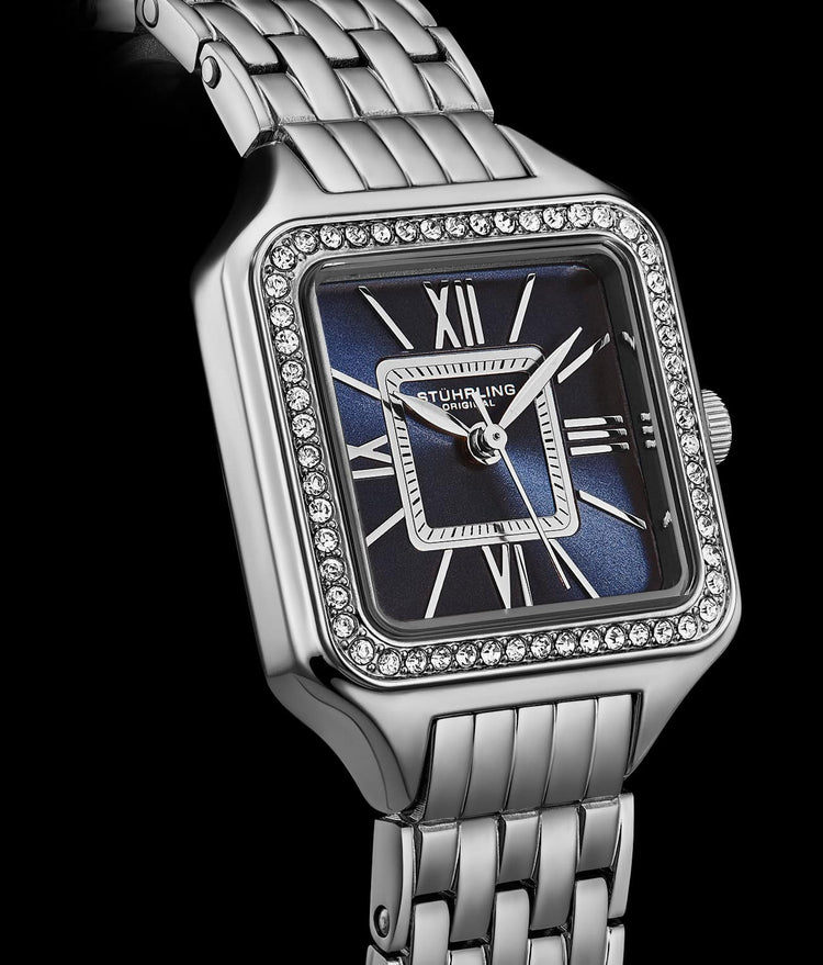 Silver watch with a blue face and diamond accents on a black background