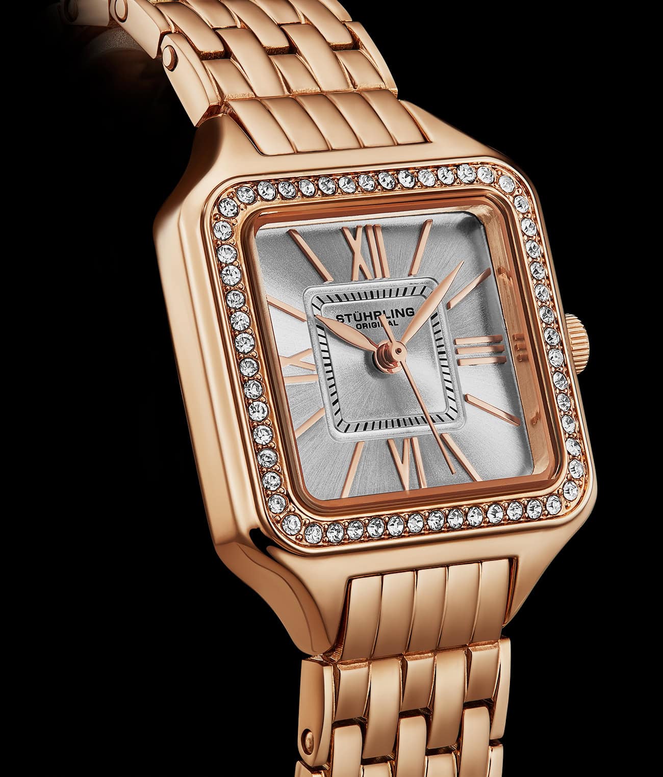 Rose gold watch with diamond-studded face on a black background