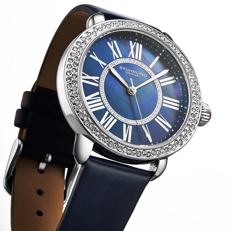 Luxury watch with blue face and black strap on white background