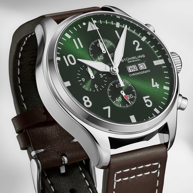 Watch with green dial and brown leather strap on a light gray background