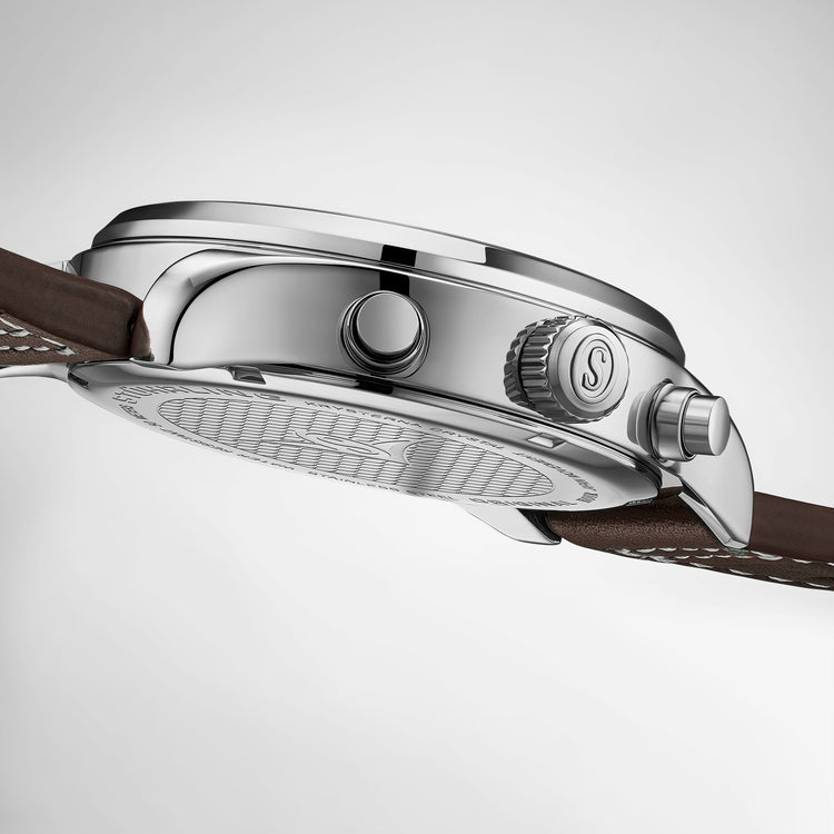 Close-up of a silver watch with a brown leather strap on a light gray background