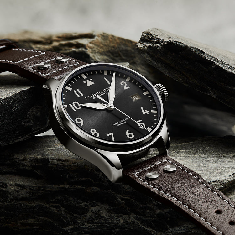 Stuhrling watch with brown leather strap on a stone surface