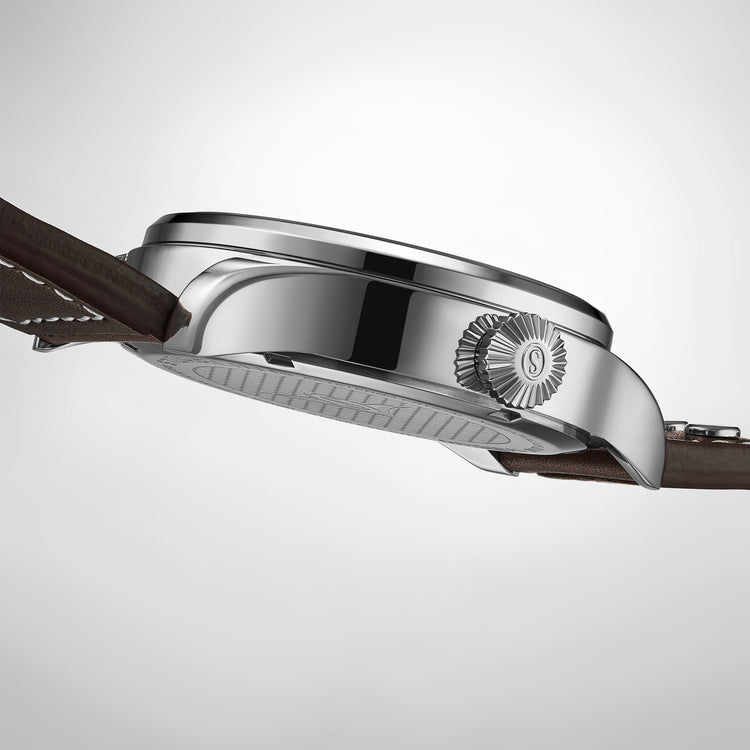 Close-up of a silver watch with a brown leather strap on a light gray background