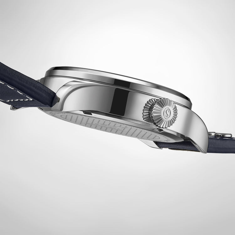 Close-up of a silver watch case with a brand logo on a light gray background