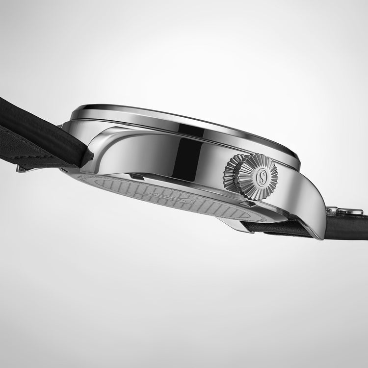 Close-up of a watch with a silver case and black strap on a light gray background