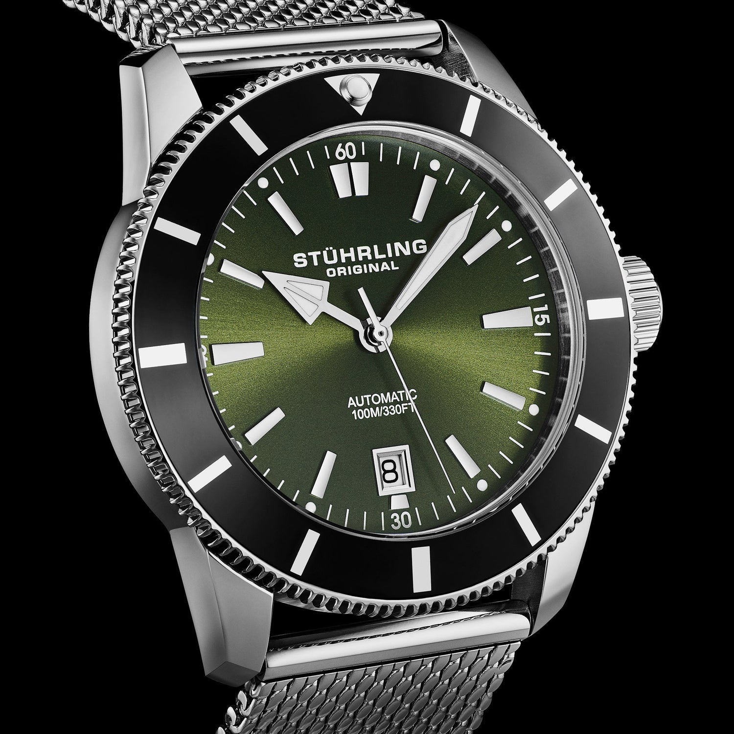 Stuhrling watch with green face and silver mesh band on black background