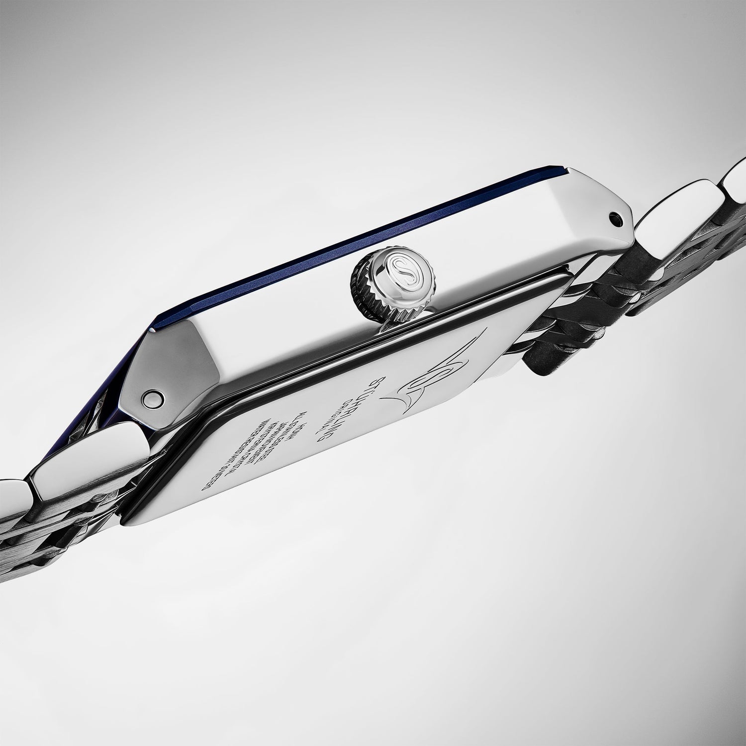 Close-up of a silver watch with a blue strap on a light gray background