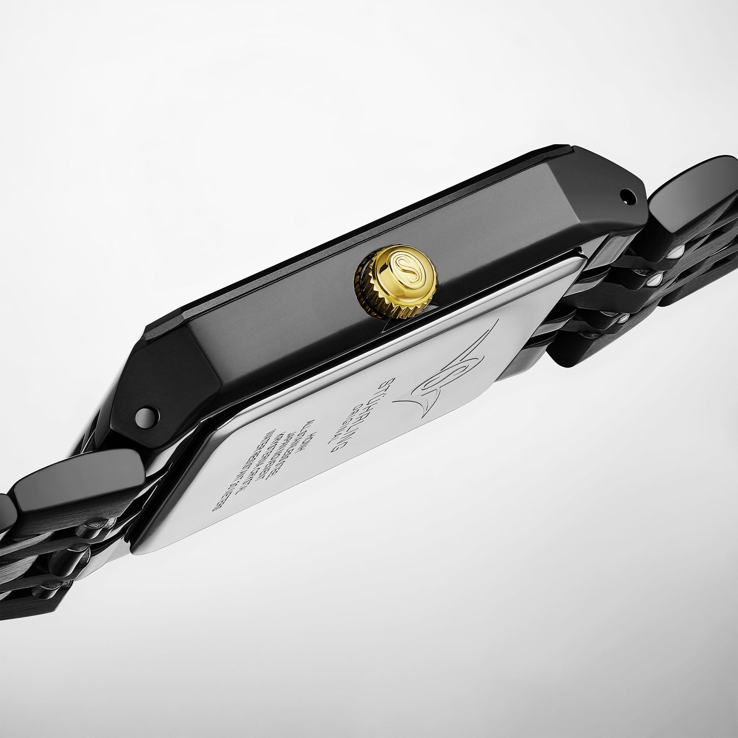 Close-up of a black watch band with a gold clasp on a light gray background