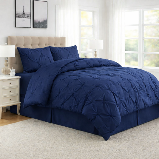 Navy blue comforter set on a bed in a bedroom with white walls and decor.