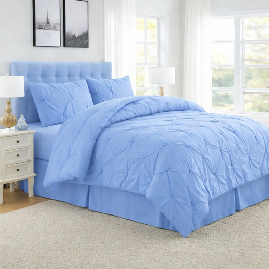 Blue comforter set on a bed in a bedroom with lamps and decor.