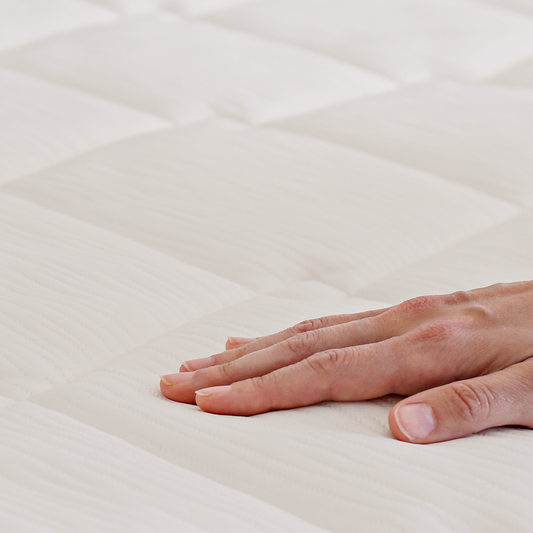Woman peeking out from under a blanket in a bedroom setting