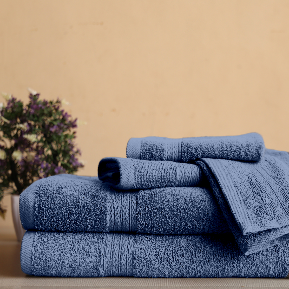 Set of blue towels on a wooden surface with a beige background