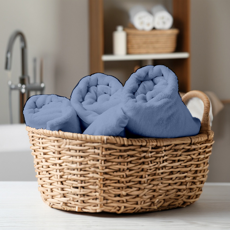 Wicker basket with blue towels in a bathroom setting