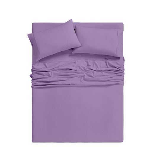 Purple bedding set on a bed in a room with large windows.