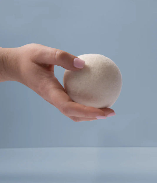 Box of wool dryer balls with oil scents on a gray background
