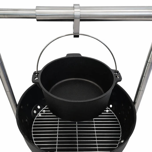Grill with skewers of meat over an open flame on a wooden deck.