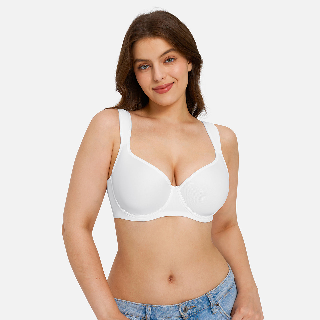 A woman modeling a white seamless underwire bra against a light gray studio background.