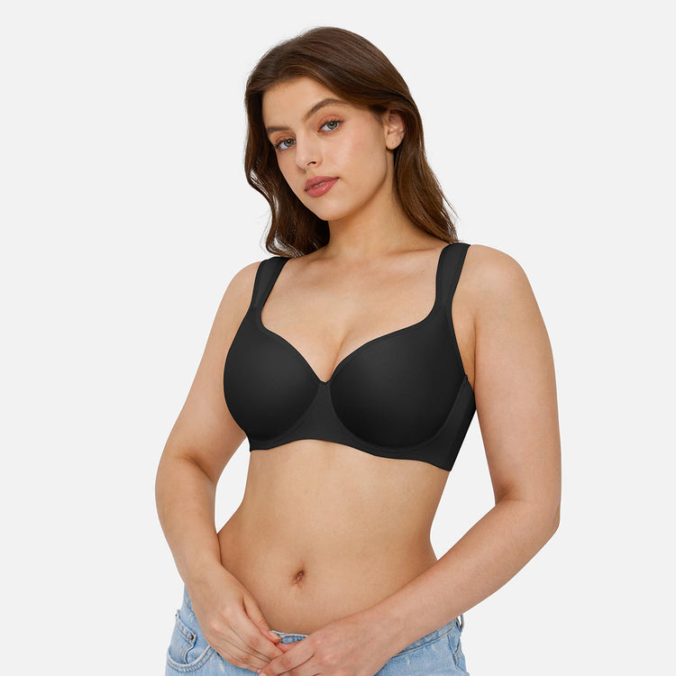 A woman modeling a black wireless underwire bra against a light gray studio background.