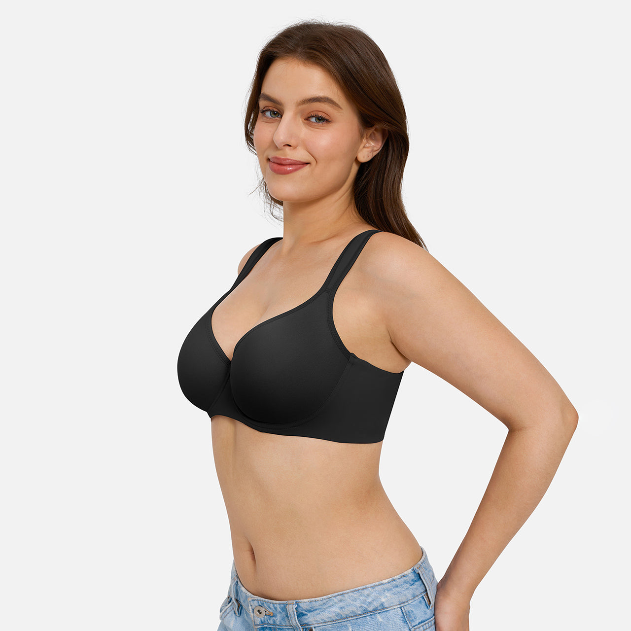 A woman modeling a black wireless bralette against a light gray studio background.