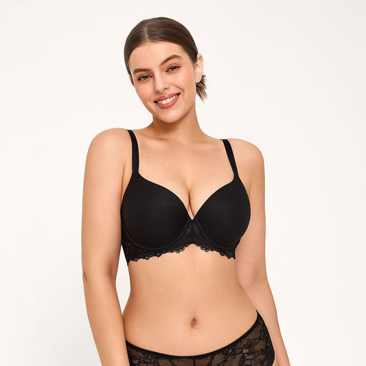 A woman modeling a black underwire bra with lace trim, styled with an open white shirt against a plain light background.