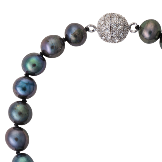 Necklace with dark pearls and a textured silver clasp on a white background