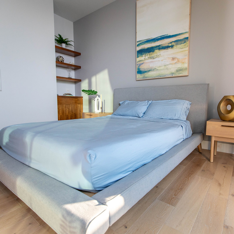 Modern bedroom with a bed, nightstands, and abstract art on the wall.
