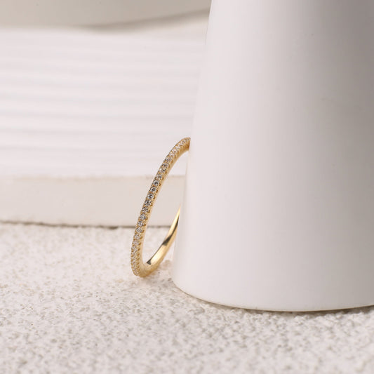 Gold ring with small diamonds on a white background