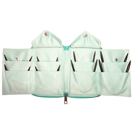 Collection of knitting needles in a teal case with product packaging on a white background