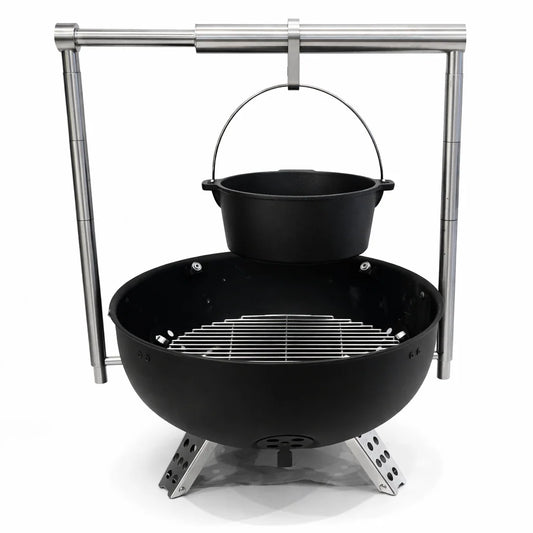 Grill with skewers of meat over an open flame on a wooden deck.