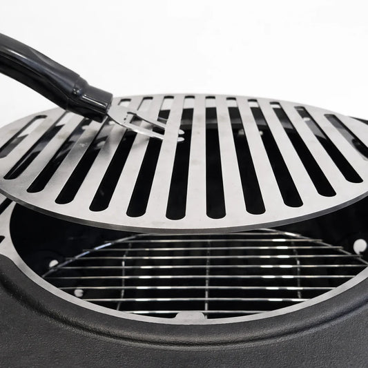 Portable grill with food being cooked on a wooden table outdoors