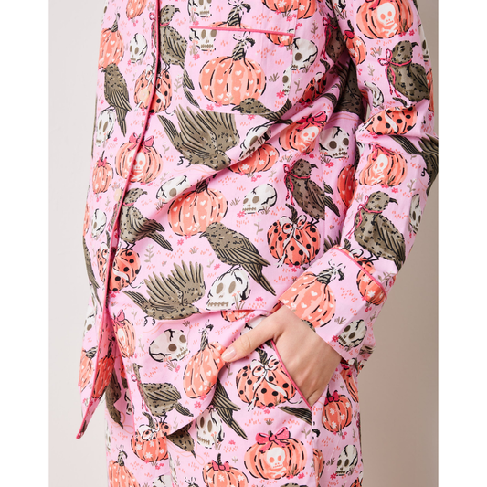 Woman wearing a pink floral onesie against a plain background