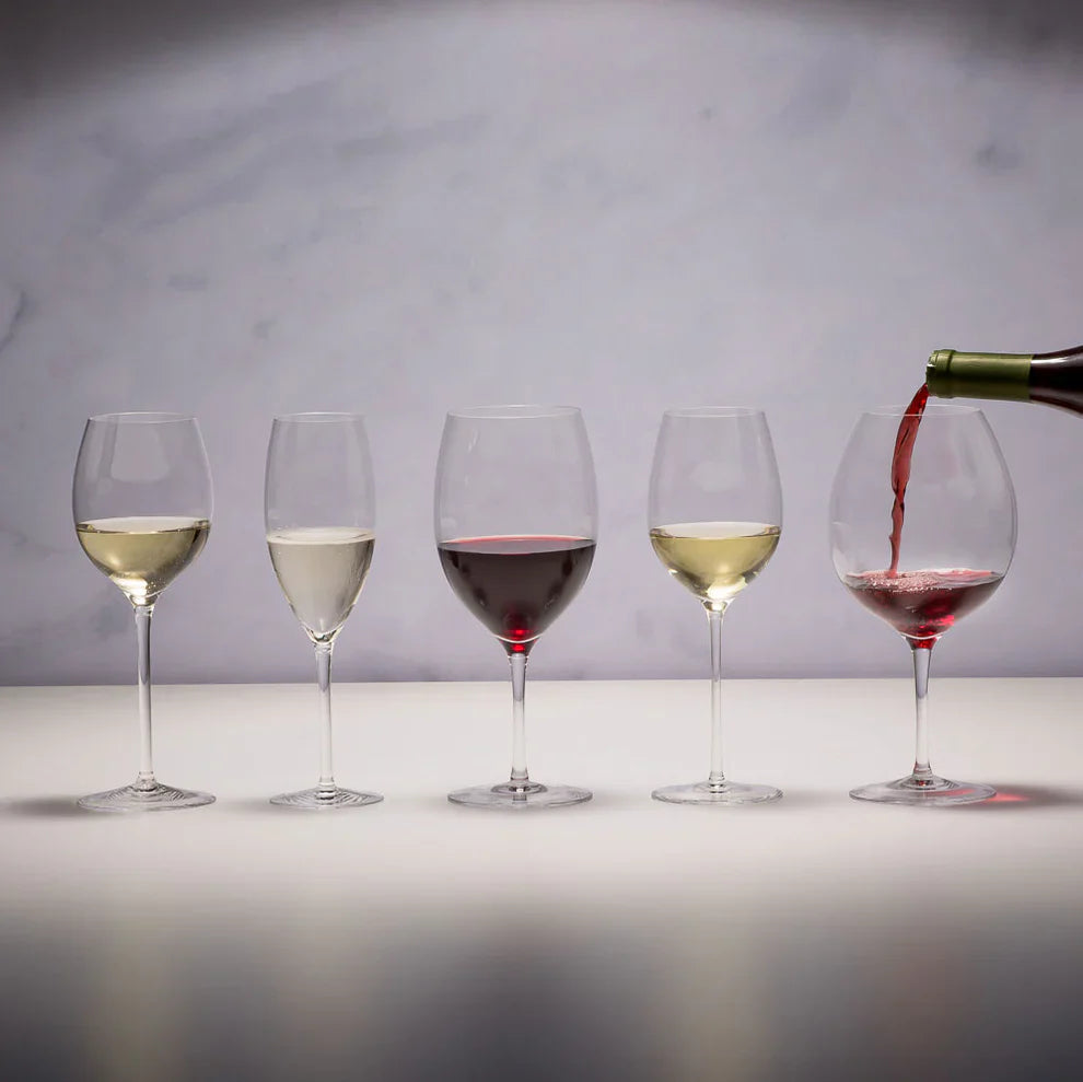 Five wine glasses with different types of wine on a neutral background