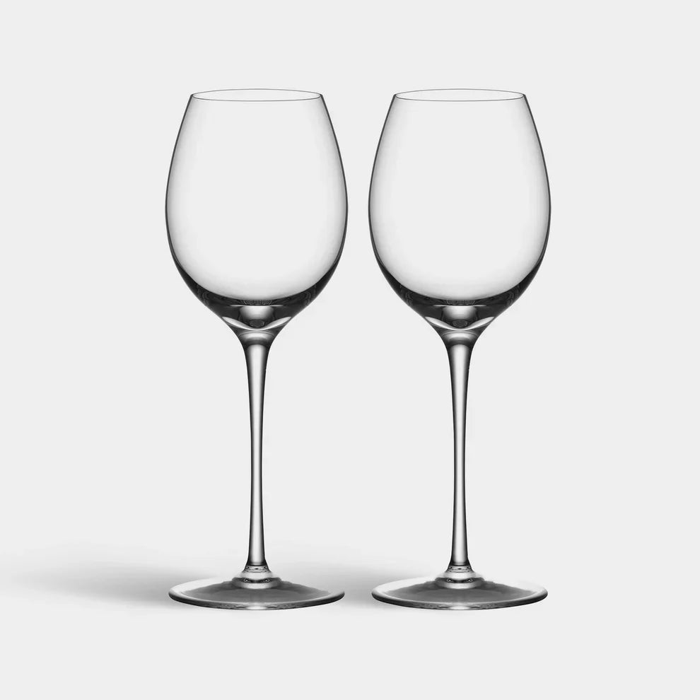 Two clear wine glasses on a light gray background