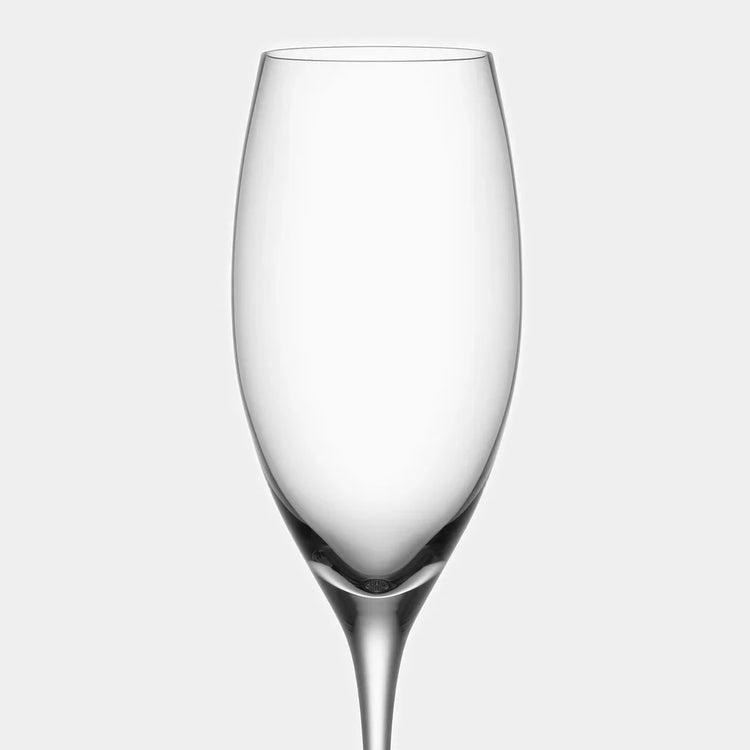 Clear glass champagne flute on a light gray background