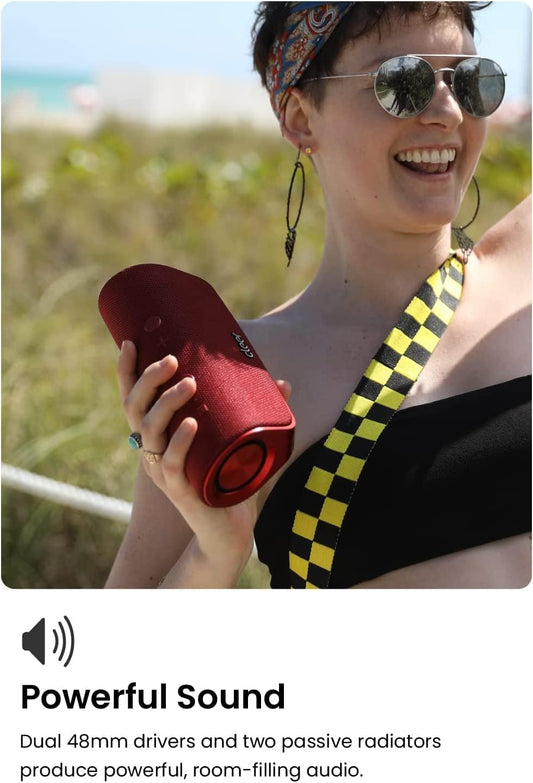 Red portable speaker with 'cleer' branding on a concrete surface outdoors.